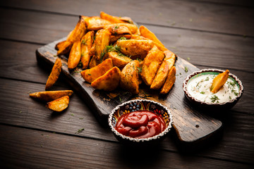 Baked potato fries on wooden table