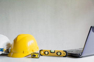 Construction tools or safety equipment with yellow helmet on table.