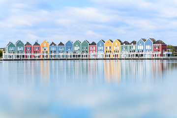 Vivid dutch wooden houses village on canal on sunny day