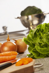 FRESH LETTUCE BROCOLLI CARROTS AND ONIONS ON KITCHEN WORKTOP