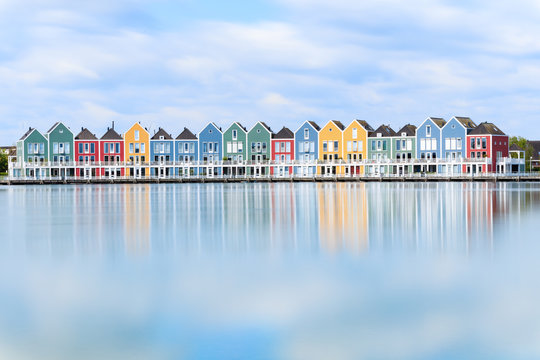 Vivid dutch wooden houses village on canal on sunny day