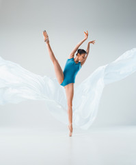 Modern ballet dancer dancing in full body on white studio background.