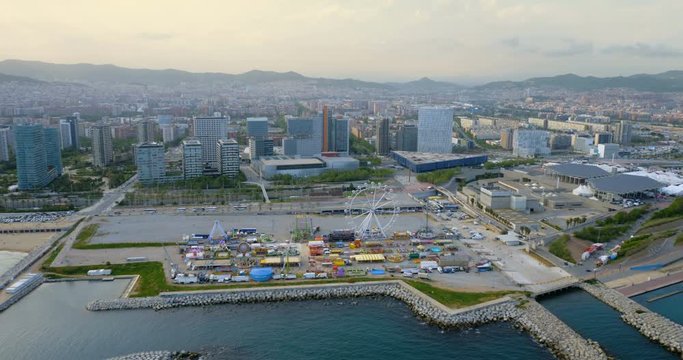 Barcelona skyline aerial view with modern buildings and amusement park by the beach, Spain. Late afternoon light