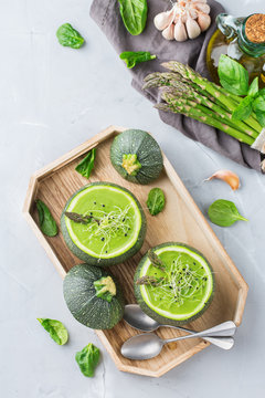 Seasonal creamy asparagus spinach soup served in a round zucchini