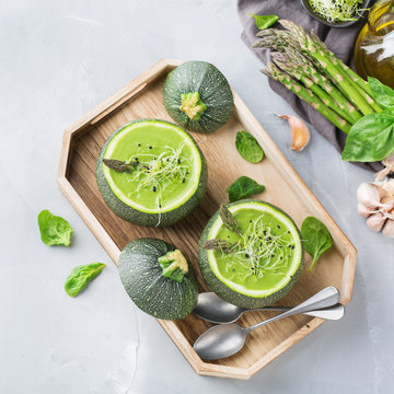 Seasonal creamy asparagus spinach soup served in a round zucchini