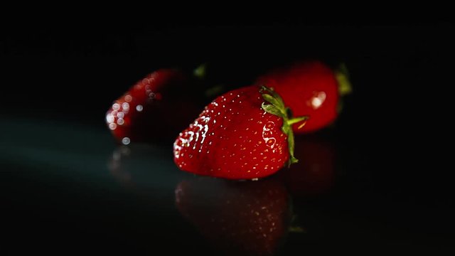 Fresh strawberries on a black background in the dark.
