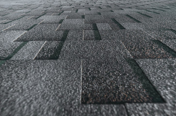 Soft roof tiled gray grainy texture on the top of a summer house lit by the sun; grey soft roofing...