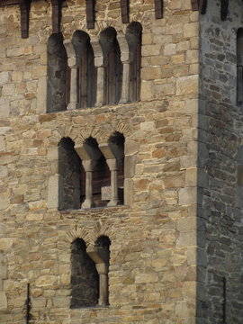 Detail of Romanesque stone masonry with typical arched windows, medieval architecture Czech republic, old tower of the church
