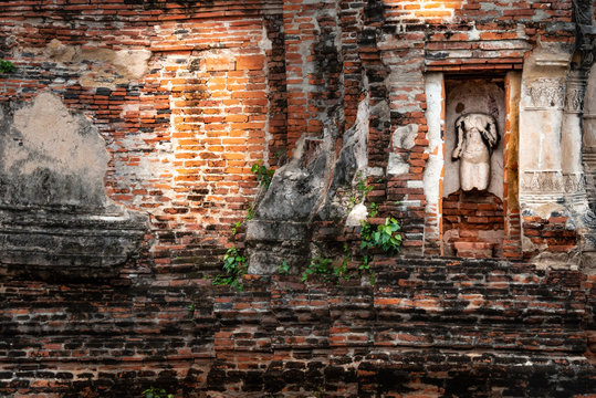 Siamesische Ruinenstadt Ayutthaya: Alte Mauer mit kopflosem Torso in Wandnische