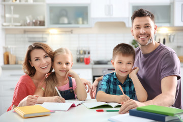 Fototapeta na wymiar Little children with parents doing homework at home