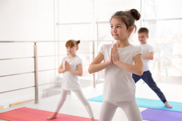 Fototapeta na wymiar Little children practicing yoga in gym