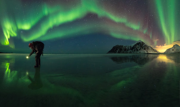 Person on ice during northern lights