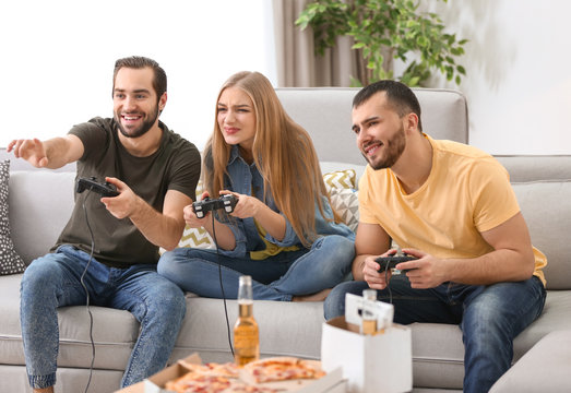 Young people playing video games at home