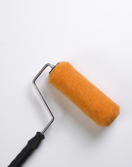 Obraz premium BRIGHT ORANGE PAINT ROLLER ON WHITE SURFACE