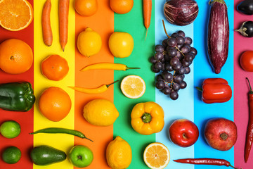 Rainbow composition with fresh vegetables and fruits on color background, flat lay