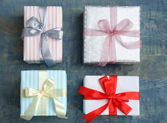 Beautifully decorated gift boxes on wooden background, top view