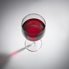 SINGLE GLASS OF RED WINE ON WHITE BACKGROUND