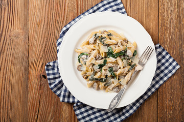 Penne pasta with spinach and mushrooms. Sprinkled with cheese.