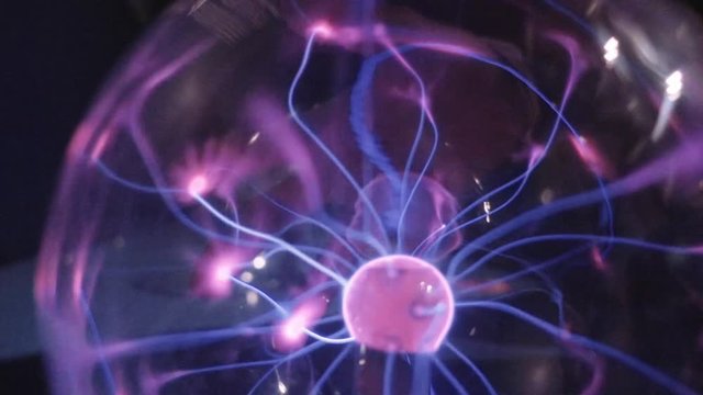Plasma ball lamp energy, hand touching glowing glass sphere concept for power, electricity, science and physics. Slow motion