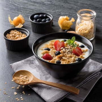 Healthy breakfast. yogurt with fresh berries and cereal on marble. Top view.