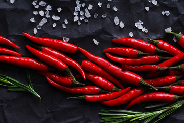 Red chili pepper on black rumpled paper.