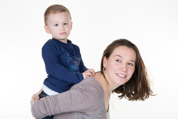 young boy in blue tshirt piggyback on the shoulders of his mother plays