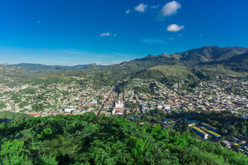 Fototapeta na wymiar nice aerial view of city surrounded by forest and mountains