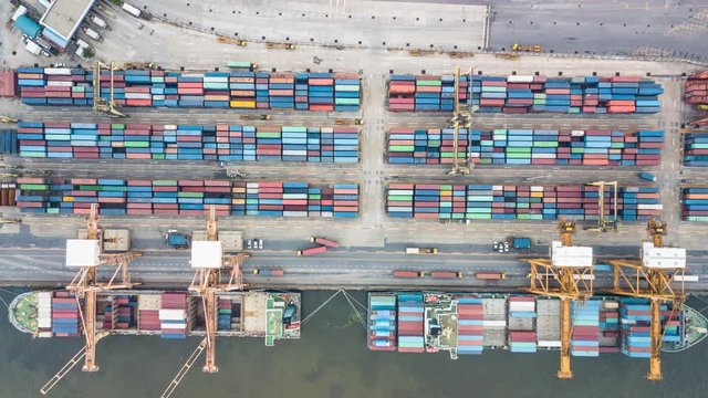 Container ship in export and import business and logistics in Thailand. Shipping cargo to harbor by crane. Water transport International. Aerial view timelapse
