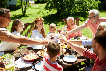 leisure, holidays and people concept - happy family having festive dinner or summer garden party and celebrating