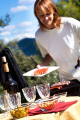 femme qui fait un barbecue avec des saucisses