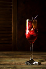 strawberry jive cocktail with ice and lavender on wooden background