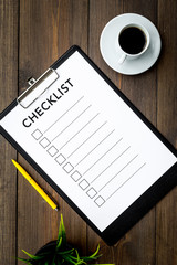 Fototapeta na wymiar Blank checklist with space for ticks on pad on office desk. Checklist for office worker, manager, businessman, chief on dark wooden background top view