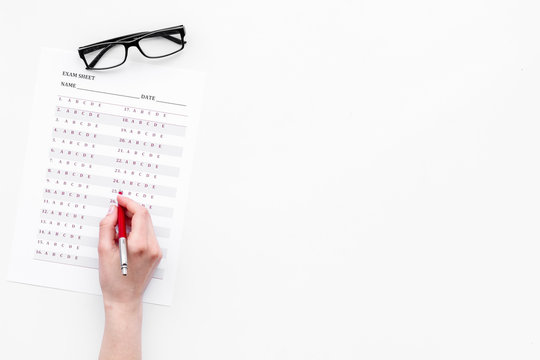 Take the exam, write the exam. Hand with pen near exam paper on white background top view copy space