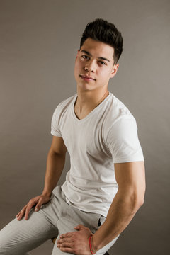 Young man sitting on chair in studio