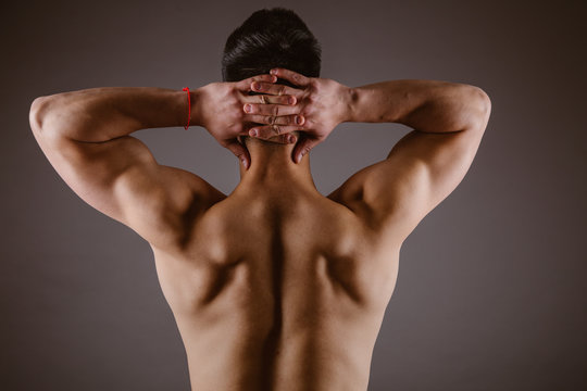 Man muscular back on dark background