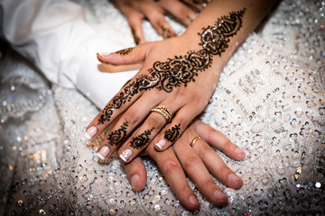 la main tatouée au henné d'une femme arabe posée sur celle de son mari, le jour de leur mariage