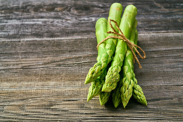 Fresh green shoots of asparagus on a gray wooden background