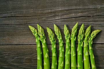 Fresh green shoots of asparagus on a gray wooden background