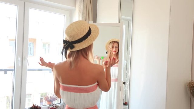 Young girl dressing up for a summertime vacation near a mirror