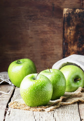 Green apples on vintage wooden background, selective focus