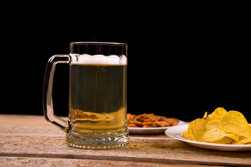 on a wooden table is a mug of foaming beer. close-up.