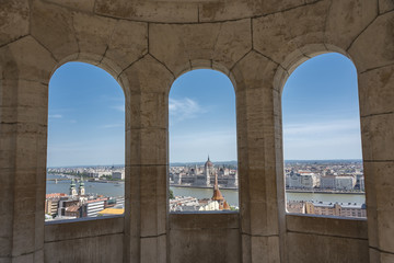 Panorama of Budapest and hungarian Parliament through three arches of Fisherman's Bastion on Buda side in sunny day