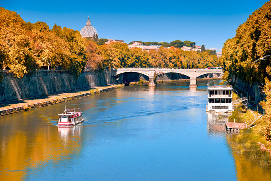 Riverside in Fall with Vatican St Peter Basilica and old bridge crossing Tiber River in Rome
