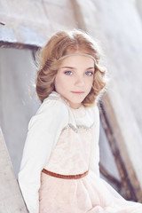 Charming little girl model posing in a studio.