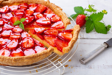 Homemade strawberry tart decorated with strawberry leaves close up - obrazy, fototapety, plakaty