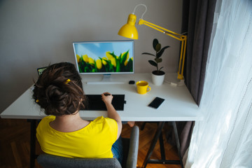 freelancer designer woman working at home. workplace white desk with yellow lamp