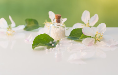Bottle of homeopathic globules and flowers