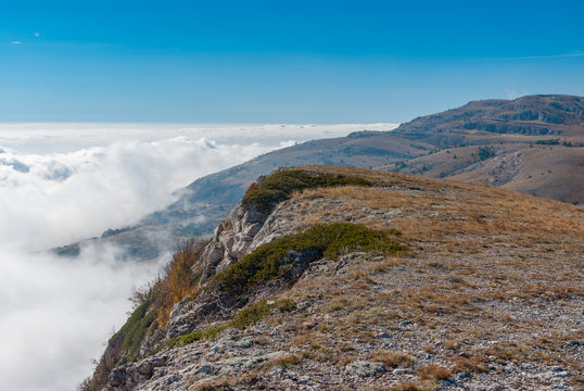 Autumnal landscape with Babuhan Yaila natural reserve with blanket of fog arisen from the Black Sea  in Crimean peninsula
