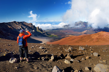 Tourist hiking in Haleakala volcano crater on the Sliding Sands trail. Beautiful view of the crater floor and the cinder cones below. Maui, Hawaii © MNStudio