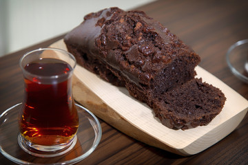 Home made delicious cocoa cake over wooden plate and Turkish tea
